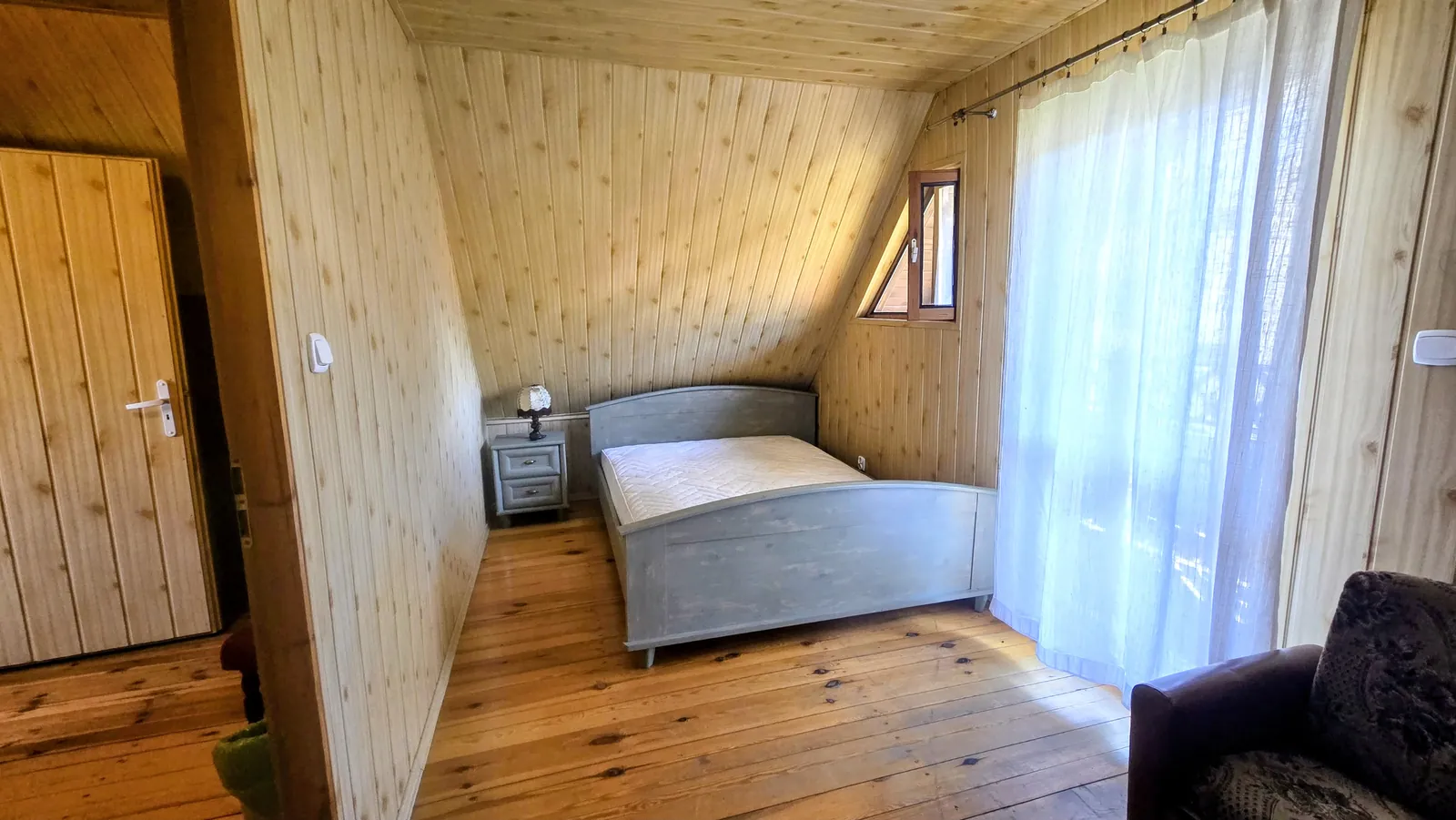 Domek 1 w ośrodku Ambrowil w Lidzbarku Welskim – sypialnia z łóżkiem dwuosobowym i wyjściem na balkon lub taras