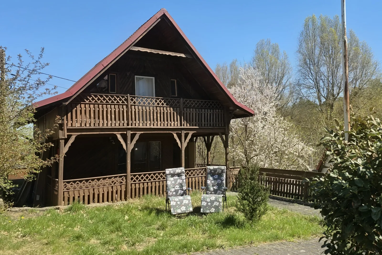 Domek 1 w ośrodku Ambrowil w Lidzbarku Welskim – widok z zewnątrz na drewniany domek z balkonem