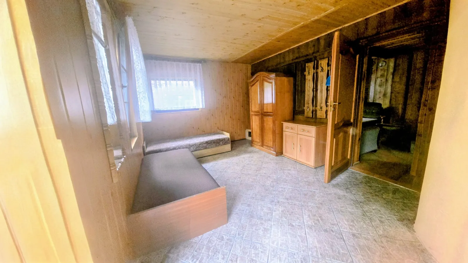 Domek 2 w ośrodku Ambrowil w Lidzbarku Welskim – sypialnia z dwoma łóżkami i drewnianym wykończeniem